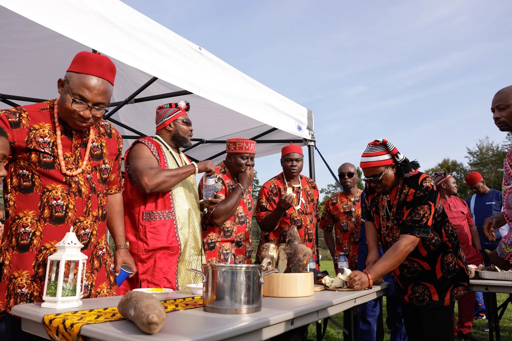 Elders in red caps break the new yam at IRI-JI